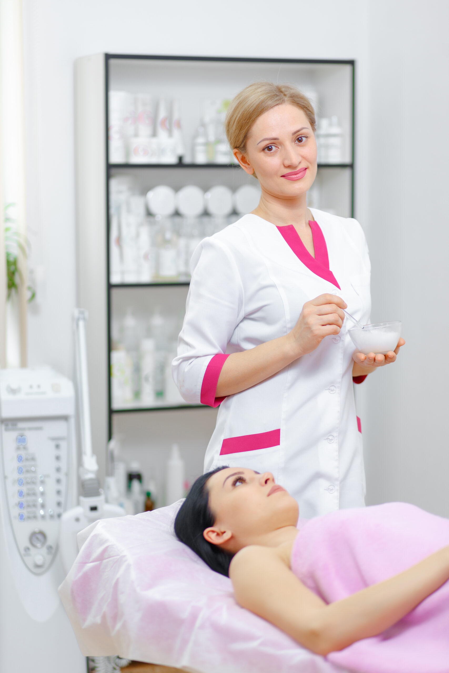 Young woman beautician is doing the cleaning procedure in the beauty salon. Face Skin Care. Cleansing Procedure. Cosmetology.